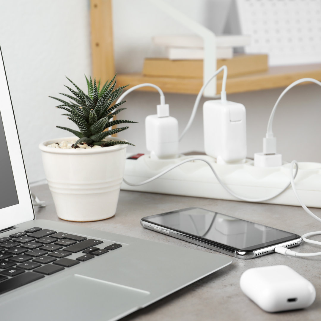 Smartphone charging with cable on light stone table